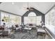 Bright sunroom features vaulted ceilings, many windows, neutral furniture, and a ceiling fan at 10896 Fairwoods Dr, Fishers, IN 46037