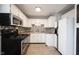 Close-up of kitchen featuring white cabinets, tile backsplash, stainless steel appliances, and tile flooring at 118 Beechwood Dr, Westfield, IN 46074