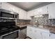 Modern kitchen with stainless steel appliances, gray backsplash, double sink, and white cabinets at 118 Beechwood Dr, Westfield, IN 46074