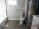 A simple bathroom with a toilet, a sink, and a water heater at 1311 E Hines St, Muncie, IN 47303