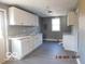 Bright kitchen with white cabinets, gray walls, and new plank flooring for a modern, clean look at 1311 E Hines St, Muncie, IN 47303