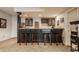 Basement bar area with dark cabinetry, wood countertop, bar stool seating, and unique lighting fixtures at 14297 Matt St, Carmel, IN 46033
