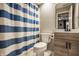 This bathroom includes a toilet, sink, mirror, and striped shower curtain at 14297 Matt St, Carmel, IN 46033