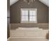 This bathroom features a large soaking tub beneath a shuttered window, illuminated by a decorative chandelier at 14297 Matt St, Carmel, IN 46033