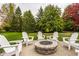 Brick patio features an inviting firepit with Adirondack chairs, perfect for outdoor gatherings at 14297 Matt St, Carmel, IN 46033