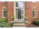 Elegant front entrance with brick facade, decorative plants, and a wreath on the door at 14297 Matt St, Carmel, IN 46033