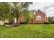 Beautiful brick home with manicured landscaping, mature trees, and well-maintained lawn at 14297 Matt St, Carmel, IN 46033