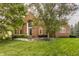 Charming two-story brick home with arched entryway, manicured lawn, and mature trees at 14297 Matt St, Carmel, IN 46033