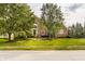 Beautiful brick home with lush green lawn and mature trees lining the street at 14297 Matt St, Carmel, IN 46033