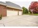 Attached two-car garage featuring multiple doors, a clean driveway, and exterior basketball hoop, making it functional and appealing at 14297 Matt St, Carmel, IN 46033