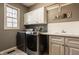 Functional laundry room with modern appliances, ample counter space, and storage cabinets at 14297 Matt St, Carmel, IN 46033