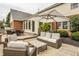 The brick patio features comfortable seating, a large umbrella, and well-manicured landscaping at 14297 Matt St, Carmel, IN 46033