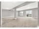 A large finished basement with neutral walls and carpet, a window, and a sliding glass door to the outside at 14474 Treasure Creek Ln, Fishers, IN 46038