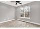 Carpeted bedroom with a window overlooking an outdoor view and a modern ceiling fan at 14474 Treasure Creek Ln, Fishers, IN 46038