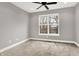 Bright bedroom features a ceiling fan, neutral paint, and large window with outdoor views at 14474 Treasure Creek Ln, Fishers, IN 46038