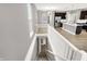 Hallway showcasing staircase leading to a kitchen featuring modern stainless steel appliances and ample countertop space at 14474 Treasure Creek Ln, Fishers, IN 46038