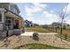 View of a backyard featuring a stone walkway, rock garden, green lawn, and a glimpse of neighboring homes at 15675 Woodford Dr, Westfield, IN 46074