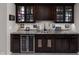The bar area showcases dark wood cabinets with glass fronts and a wine refrigerator offering an elegant space for entertaining at 15675 Woodford Dr, Westfield, IN 46074