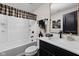 Classic bathroom featuring a shower and bathtub combo, a black vanity with white countertops, and a decorative mirror at 15675 Woodford Dr, Westfield, IN 46074