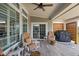 Charming covered patio with comfortable seating, wood flooring, and a grill perfect for relaxation and outdoor cooking at 15675 Woodford Dr, Westfield, IN 46074