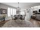 Bright dining area features a modern light fixture, wood table, and sliding doors to the backyard at 15675 Woodford Dr, Westfield, IN 46074