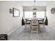 Bright dining room featuring a gray carpet, a decorative chandelier and a wood dining table surrounded by four chairs at 15675 Woodford Dr, Westfield, IN 46074
