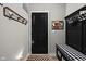 Charming entryway featuring a black accent door, coat rack, bench with storage, and stylish decor at 15675 Woodford Dr, Westfield, IN 46074