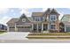 Charming two-story home with a three-car garage, covered porch, and beautiful architectural details at 15675 Woodford Dr, Westfield, IN 46074