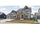 Stunning two-story home with a manicured lawn and attached three car garage and a covered porch at 15675 Woodford Dr, Westfield, IN 46074
