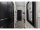 Hallway with black doors and a black-and-white checkered rug leads to an entryway with bench seating at 15675 Woodford Dr, Westfield, IN 46074