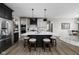 Modern eat-in kitchen with a large quartz island, stainless steel appliances, and sleek black and white cabinetry at 15675 Woodford Dr, Westfield, IN 46074