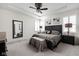 Elegant bedroom with a tray ceiling, decorative fan, neutral walls, and plush carpeting at 15675 Woodford Dr, Westfield, IN 46074