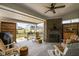 Covered back patio featuring an outdoor fireplace, ceiling fan, and views of the fenced backyard at 15675 Woodford Dr, Westfield, IN 46074