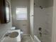 This bathroom features a shower/tub combo, a window, and a sink with a large mirror at 1624 S Jersey Ave, Muncie, IN 47302