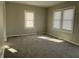Sunlit bedroom featuring plush carpeting, neutral paint, and a pair of windows at 1624 S Jersey Ave, Muncie, IN 47302