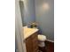 Clean half-bathroom featuring a vanity with wood drawers, and a standard toilet at 203 Village Green Dr, Indianapolis, IN 46227