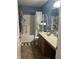 Bathroom features a shower and tub combo, a sink vanity, and decorative shelving for storage at 203 Village Green Dr, Indianapolis, IN 46227