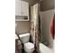 Bathroom with a toilet, patterned shower curtain, and white cabinets for storage and functionality at 203 Village Green Dr, Indianapolis, IN 46227