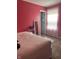 Bright bedroom with pink walls, carpeted floors, and a view into a closet or bathroom at 203 Village Green Dr, Indianapolis, IN 46227
