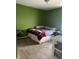 Green bedroom featuring a bed with a red blanket and a metal shelf, showcasing the room's design and layout at 203 Village Green Dr, Indianapolis, IN 46227