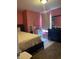 Bright bedroom with pink walls, carpeted floor, and a window dressed with light-filtering curtains at 203 Village Green Dr, Indianapolis, IN 46227