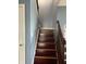 Stairway with wood steps, blue walls, and wooden handrail, offering a glimpse of the upper level at 203 Village Green Dr, Indianapolis, IN 46227