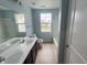 Bathroom featuring double sinks, vinyl floors, bathtub, and window with neighborhood view at 215 Traditions Pass, Greenwood, IN 46143