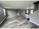 Open living room with hardwood floors, gray walls, and lots of natural light from the several windows at 215 Traditions Pass, Greenwood, IN 46143