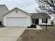 Exterior view of a single-story home featuring a garage and sidewalk leading to the front door at 2399 Orchard Creek Dr, Columbus, IN 47201