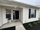 Charming front porch with a black door, modern windows, and freshly laid black mulch at 2399 Orchard Creek Dr, Columbus, IN 47201