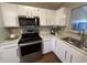 Bright kitchen features white cabinets, stainless steel appliances, and modern lighting at 2399 Orchard Creek Dr, Columbus, IN 47201