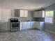 Bright kitchen featuring white cabinets, stainless steel oven, and vinyl flooring at 2905 N Barr St, Muncie, IN 47303