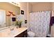 Bathroom featuring a mirror, vanity, with decorative flowers, and a shower behind a patterned curtain at 3258 Starlite Ct, Columbus, IN 47203