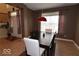 Inviting dining room with a dark wood table set for six under a modern red pendant light at 3258 Starlite Ct, Columbus, IN 47203